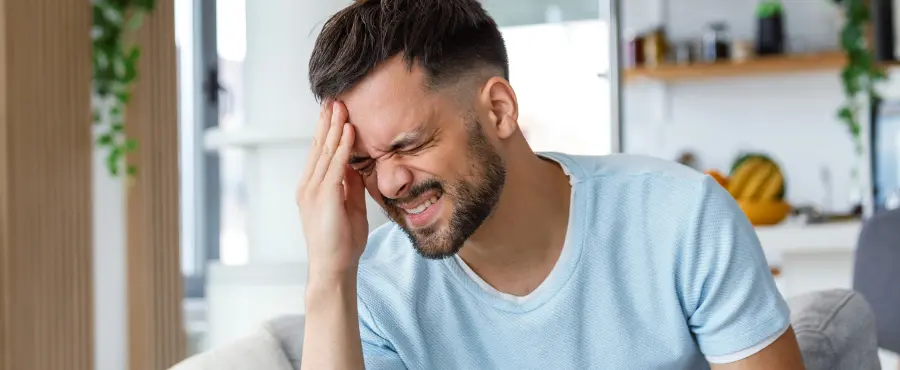 Homem com fortes dores de cabeça devido ao uso excessivo de analgésicos